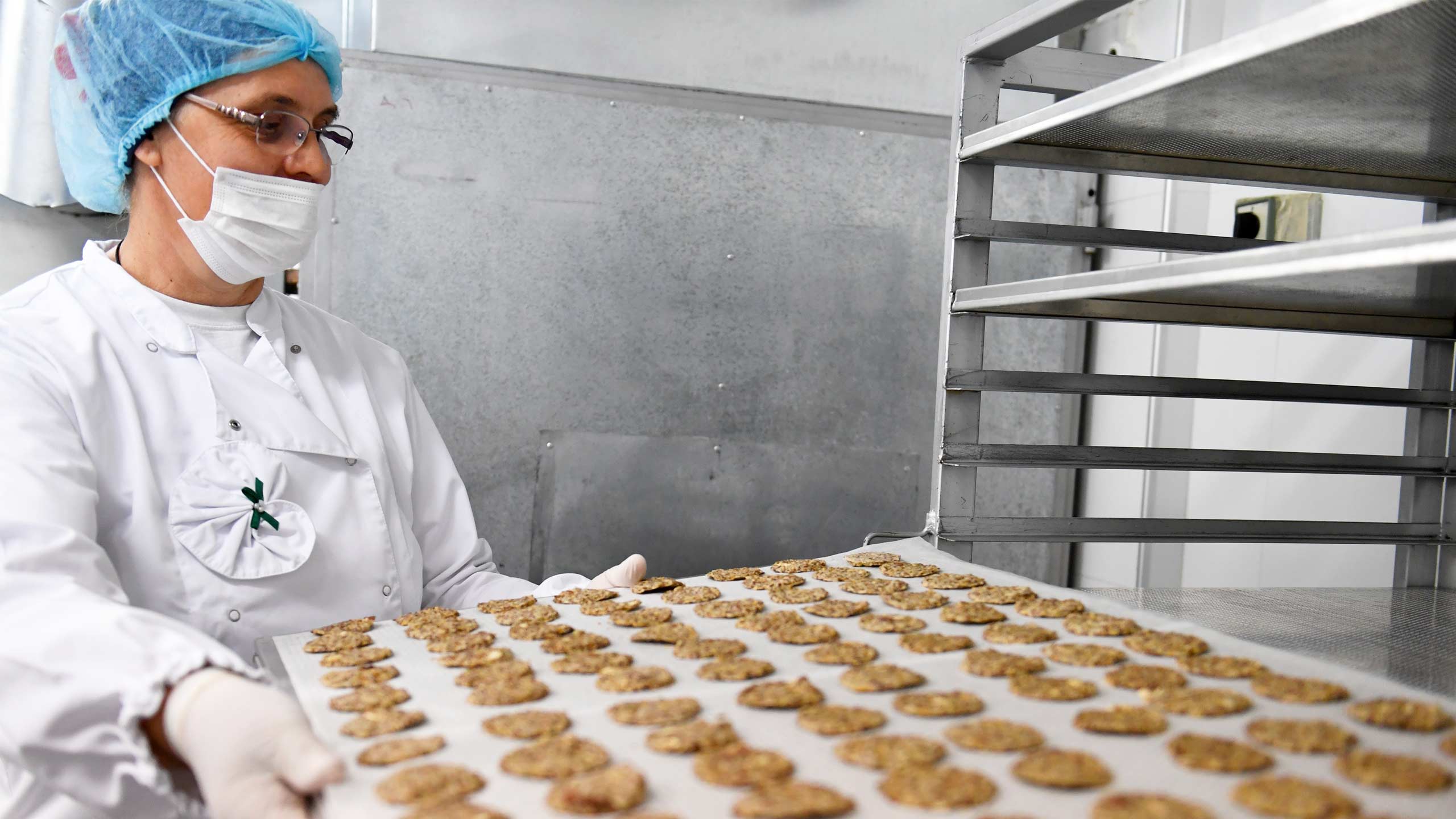 Baker putting biscuits in an oven